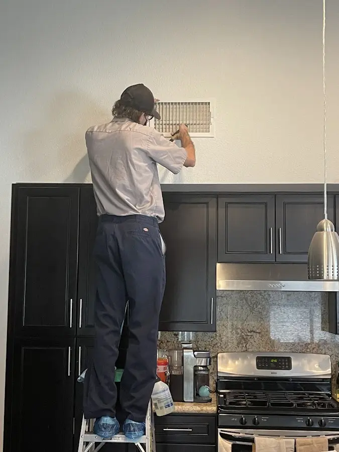 Technician inspecting an air vent during HVAC service in Gainesville